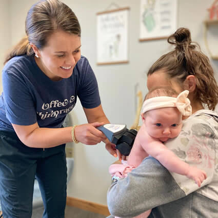 Dr. Maggie Hunsicker performing Insight CLA nervous system scan on infant at Thrive Chiropractic in Topeka Kansas